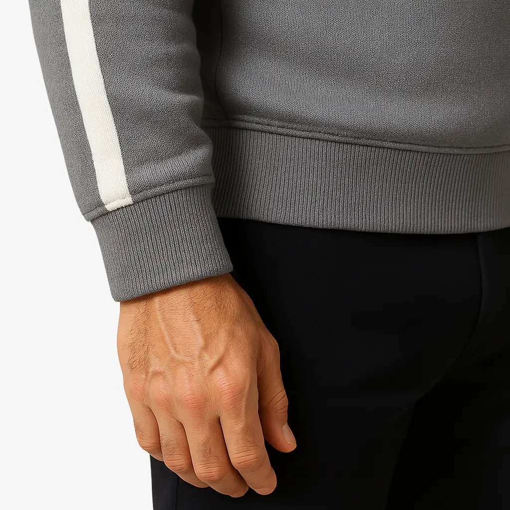 Homem maduro vestindo suéter cinza masculino com zíper e detalhes brancos nas mangas, estilo casual e sofisticado.