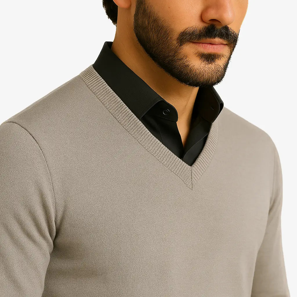 Homem vestindo suéter masculino cinza claro de tricô, com gola V e mangas compridas, ideal para o inverno.