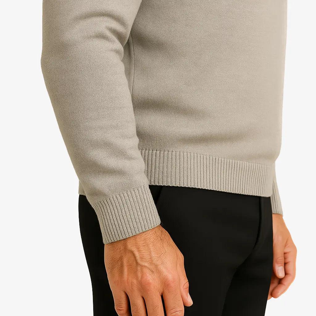 Homem vestindo suéter masculino cinza claro de tricô, com gola V e mangas compridas, ideal para o inverno.