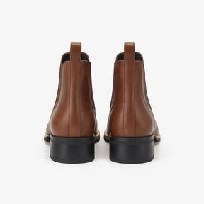 Bota Chelsea masculina estilo western marrom com bico fino e costura decorativa, solado baixo e elástico lateral.