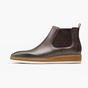 Bota Chelsea em couro legítimo com elástico lateral e solado branco.