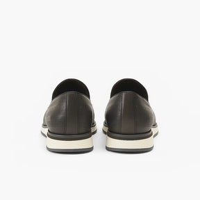 Loafer masculino com tassel e tachas metálicas, couro legítimo texturizado, solado branco e design sofisticado e moderno.