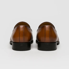 Loafer masculino vintage com fivela lateral e acabamento polido marrom, estilo retrô britânico com design elegante.