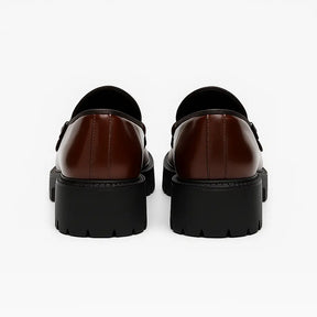 Loafer masculino tratorado com fivela dupla em couro brilhante e camurça, solado grosso preto e acabamento sofisticado.