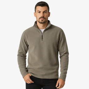 Homem estiloso vestindo suéter de lã com zíper, gola alta e textura canelada. Look casual elegante com calça chino clara para dias frios