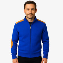 Homem vestindo suéter azul masculino com zíper e detalhes em camurça caramelo nos ombros e cotovelos, estilo casual sofisticado para o inverno.