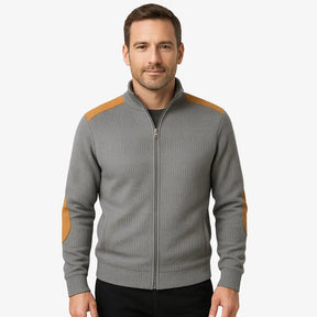 Homem vestindo suéter cinza masculino com zíper e detalhes em camurça caramelo nos ombros e cotovelos, estilo casual sofisticado para o inverno.
