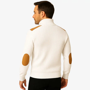 Homem vestindo suéter caqui masculino com zíper e detalhes em camurça caramelo nos ombros e cotovelos, estilo casual sofisticado para o inverno.