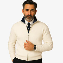 Homem elegante vestindo suéter social branco com zíper e camisa branca com gravata, estilo sofisticado para ocasiões formais.