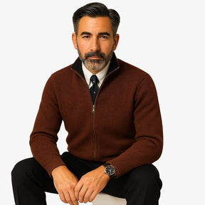 Homem elegante vestindo suéter social marrom com zíper e camisa branca com gravata, estilo sofisticado para ocasiões formais.