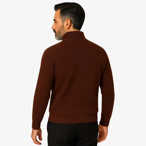 Homem elegante vestindo suéter social marrom com zíper e camisa branca com gravata, estilo sofisticado para ocasiões formais.