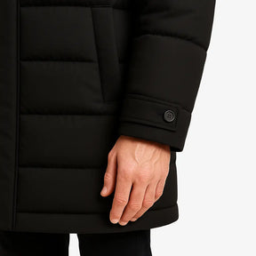 Homem vestindo jaqueta puffer masculina longa preta com capuz e bolsos verticais