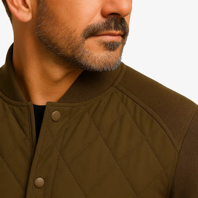 Modelo masculino usando jaqueta bomber verde acolchoada com fechamento por botões. Estilo casual elegante para dias frios. 