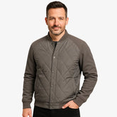 Modelo masculino usando jaqueta bomber cinza acolchoada com fechamento por botões. Estilo casual elegante para dias frios. 