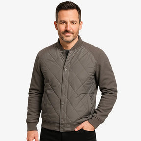 Modelo masculino usando jaqueta bomber cinza acolchoada com fechamento por botões. Estilo casual elegante para dias frios. 