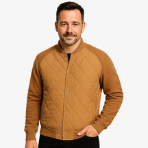 Modelo masculino usando jaqueta bomber marrom acolchoada com fechamento por botões. Estilo casual elegante para dias frios. 