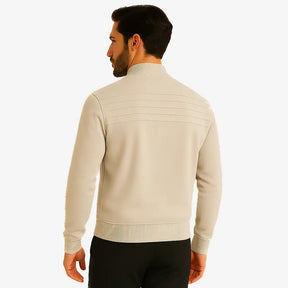 Homem usando suéter masculino bege com zíper e detalhe em relevo no peito, gola careca canelada e bolso lateral, ideal para outono/inverno.