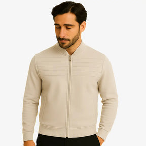 Homem usando suéter masculino bege com zíper e detalhe em relevo no peito, gola careca canelada e bolso lateral, ideal para outono/inverno.