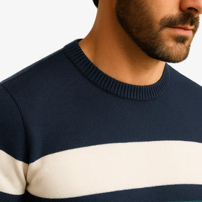 Homem vestindo suéter masculino listrado azul marinho, branco e verde, com gola redonda e manga comprida. Look casual para o inverno.
