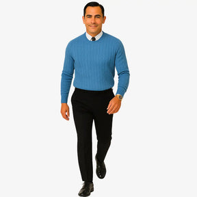 Homem elegante vestindo suéter gola redonda com textura em tramas verticais, camisa branca e gravata preta. Look sofisticado com calça preta para outono/inverno