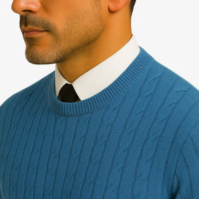 Homem elegante vestindo suéter gola redonda com textura em tramas verticais, camisa branca e gravata preta. Look sofisticado com calça preta para outono/inverno