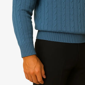 Homem elegante vestindo suéter gola redonda com textura em tramas verticais, camisa branca e gravata preta. Look sofisticado com calça preta para outono/inverno