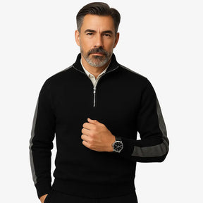Homem maduro vestindo suéter preto masculino com zíper e detalhes brancos nas mangas, estilo casual e sofisticado.