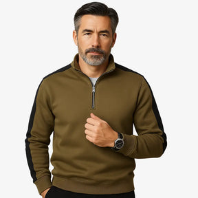 Homem maduro vestindo suéter verde masculino com zíper e detalhes brancos nas mangas, estilo casual e sofisticado.