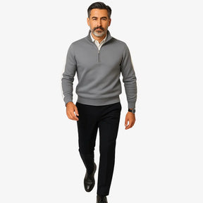 Homem maduro vestindo suéter cinza masculino com zíper e detalhes brancos nas mangas, estilo casual e sofisticado.