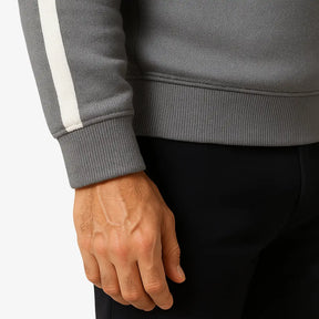 Homem maduro vestindo suéter cinza masculino com zíper e detalhes brancos nas mangas, estilo casual e sofisticado.