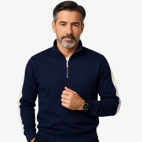 Homem maduro vestindo suéter azul marinho masculino com zíper e detalhes brancos nas mangas, estilo casual e sofisticado.